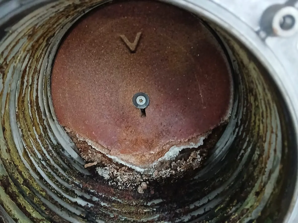 Geöffnete Brennkammer eines Heizgeräts mit Rost und Ablagerungen